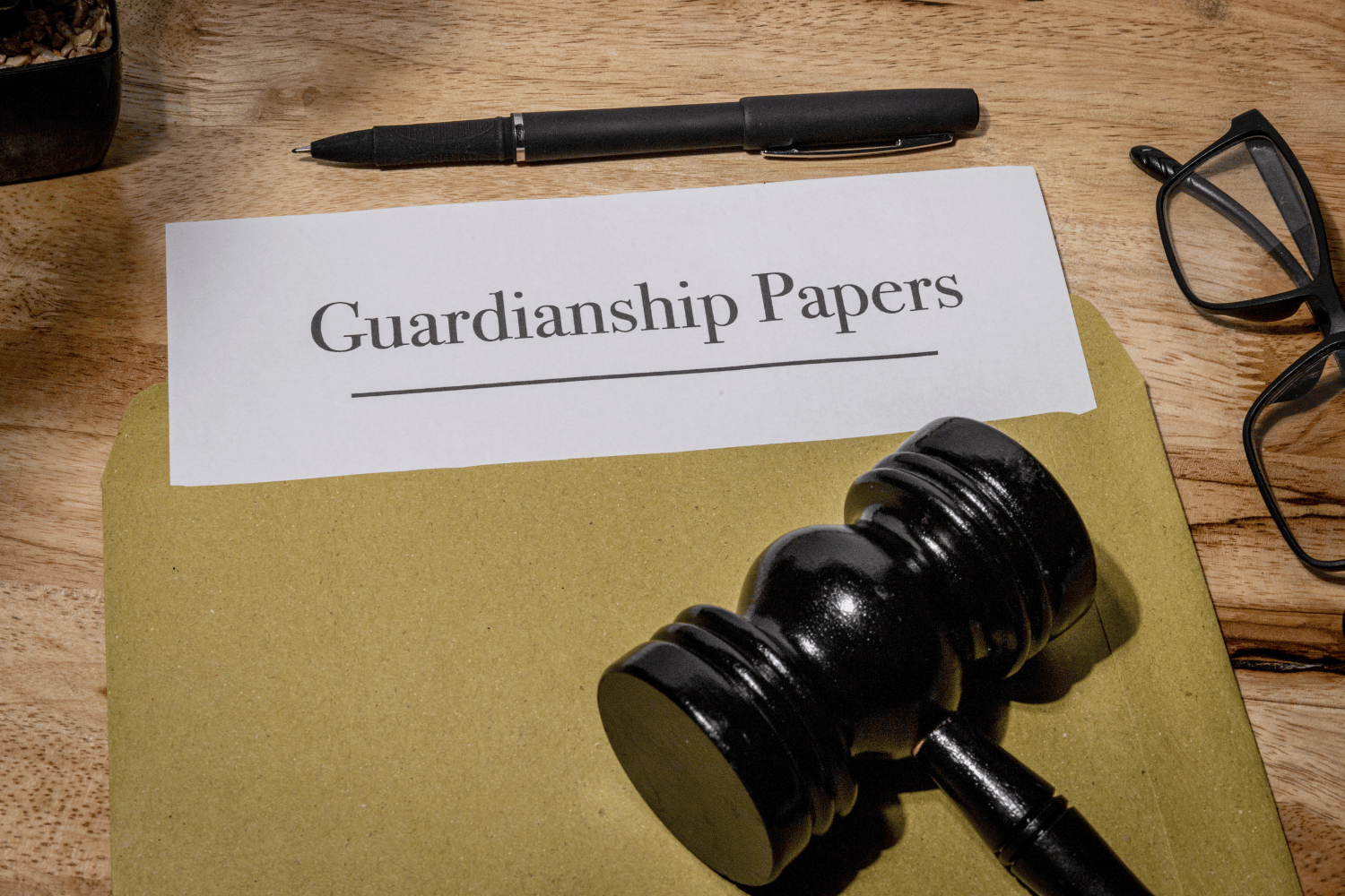 Guardianship papers beside a pen and gavel on a desk, suggesting legal paperwork.
