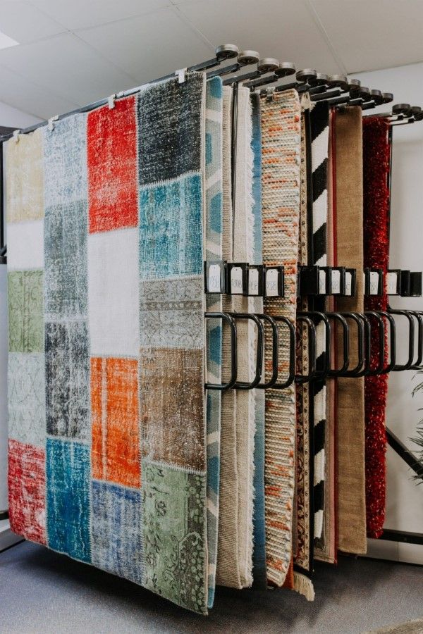 A Bunch of Colourful Rugs Are Hanging on a Rack in a Store — BTS Blinds & Awnings in Gunnedah, NSW