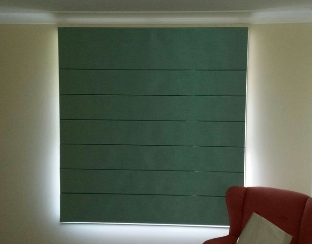 A Living Room With a Green Blind on the Window — BTS Blinds & Awnings in Gunnedah, NSW
