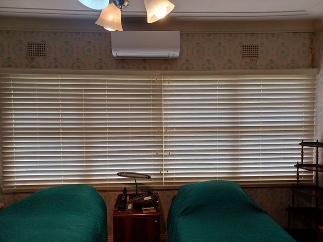 A Bedroom With Two Beds and a Ceiling Fan — BTS Blinds & Awnings in Gunnedah, NSW