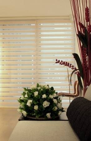 A Living Room With a Couch and a Vase of Flowers on a Table — BTS Blinds & Awnings in Gunnedah, NSW
