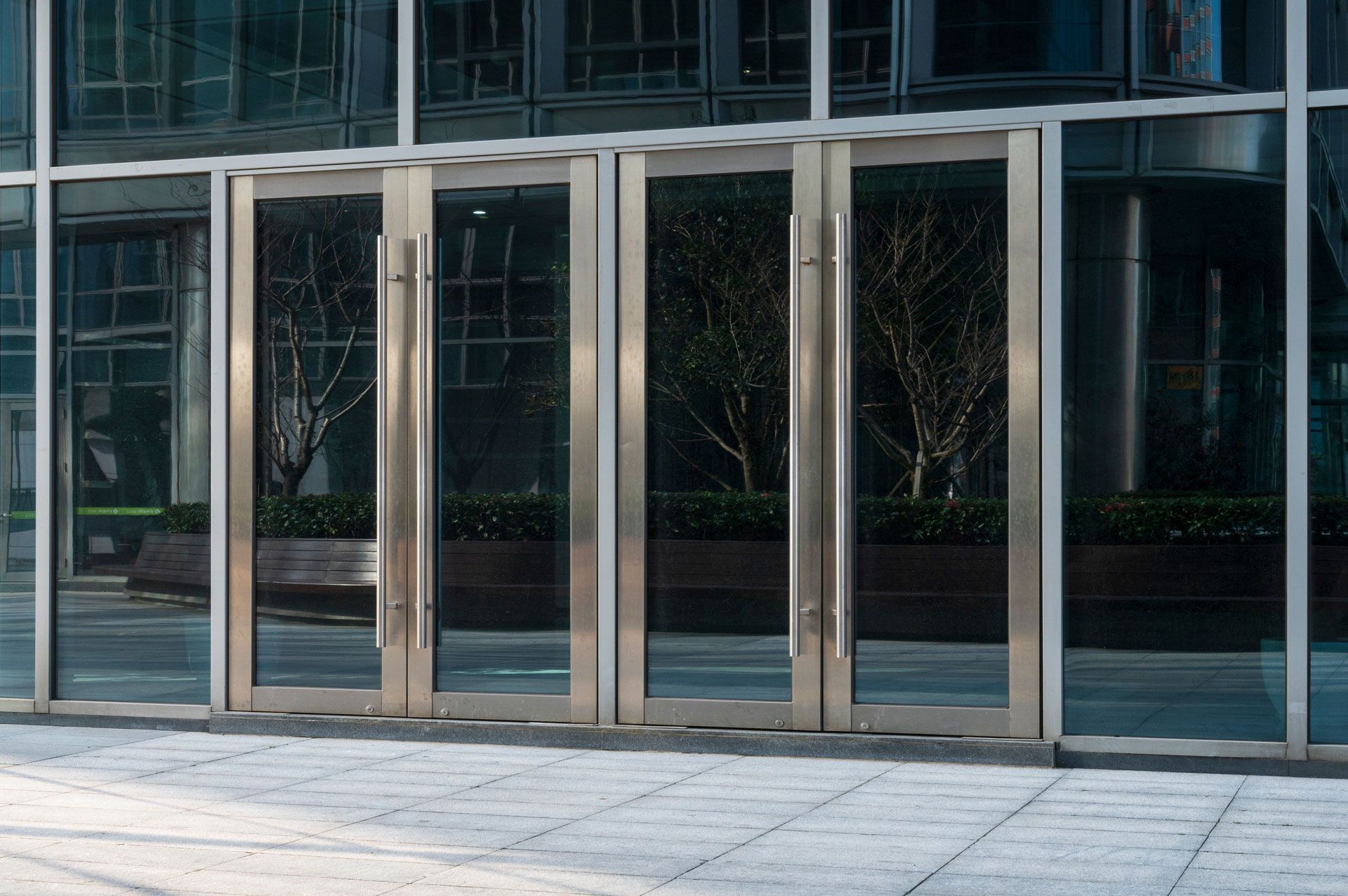 Glass storefront entrance with silver-framed double doors and dark-tinted windows