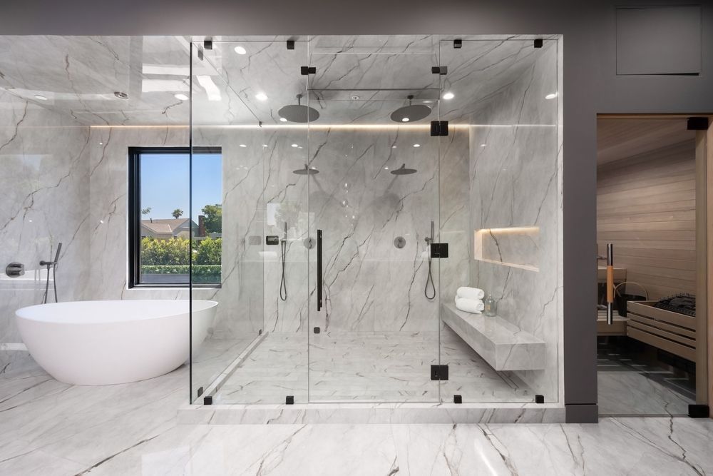 Luxurious bathroom with glass-enclosed shower, freestanding tub, and marble walls.