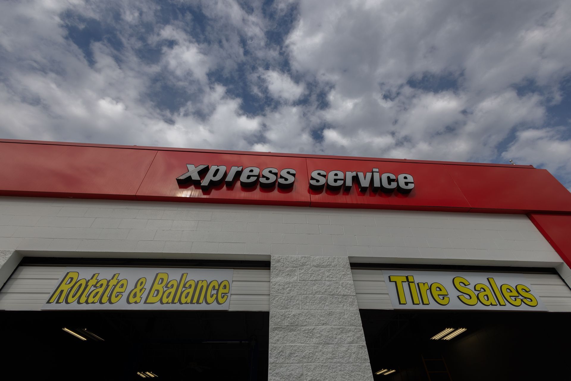 A red and white xpress service building with a blue sky in the background