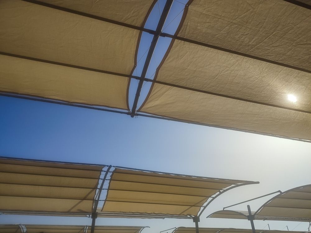 Beige Shade Sails Against a Bright Blue Sky — Professional Shade Sail Installation in Noosa, QLD