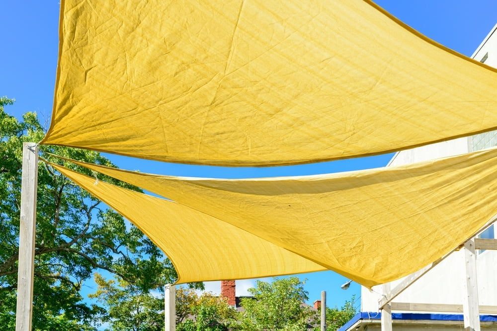 Yellow Shade Sails Against a Blue Sky — Professional Shade Sail Installation in Mooloolaba, QLD