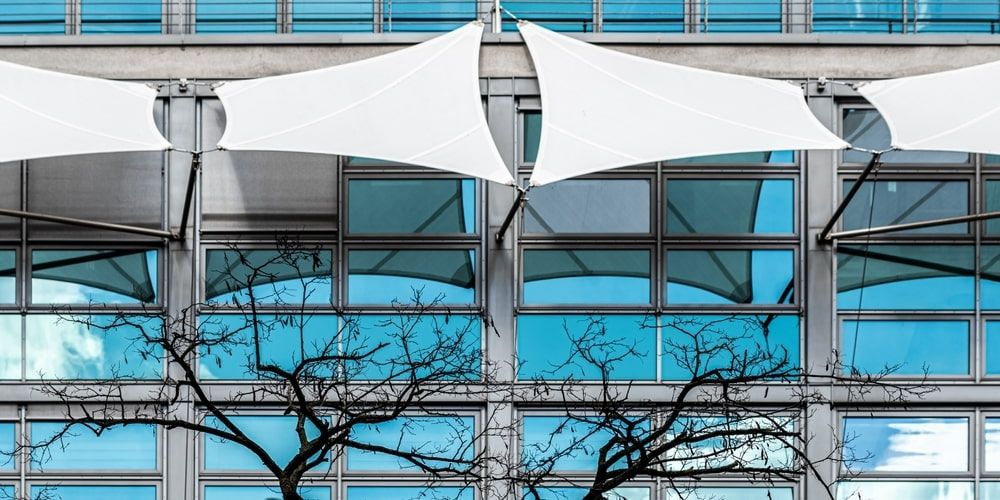 White Canopy Shades a Building — Professional Shade Sail Installation in Maroochydore, QLD