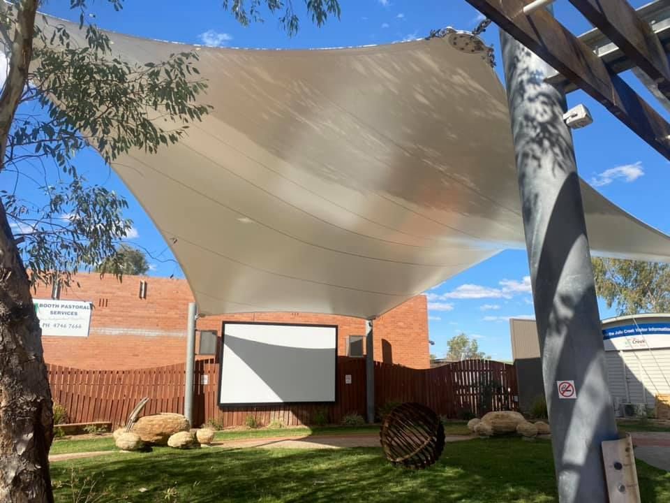Grass Area with a Large Blank Board Under a Shade Sail — Professional Shade Sail Installation in Townsville, QLD
