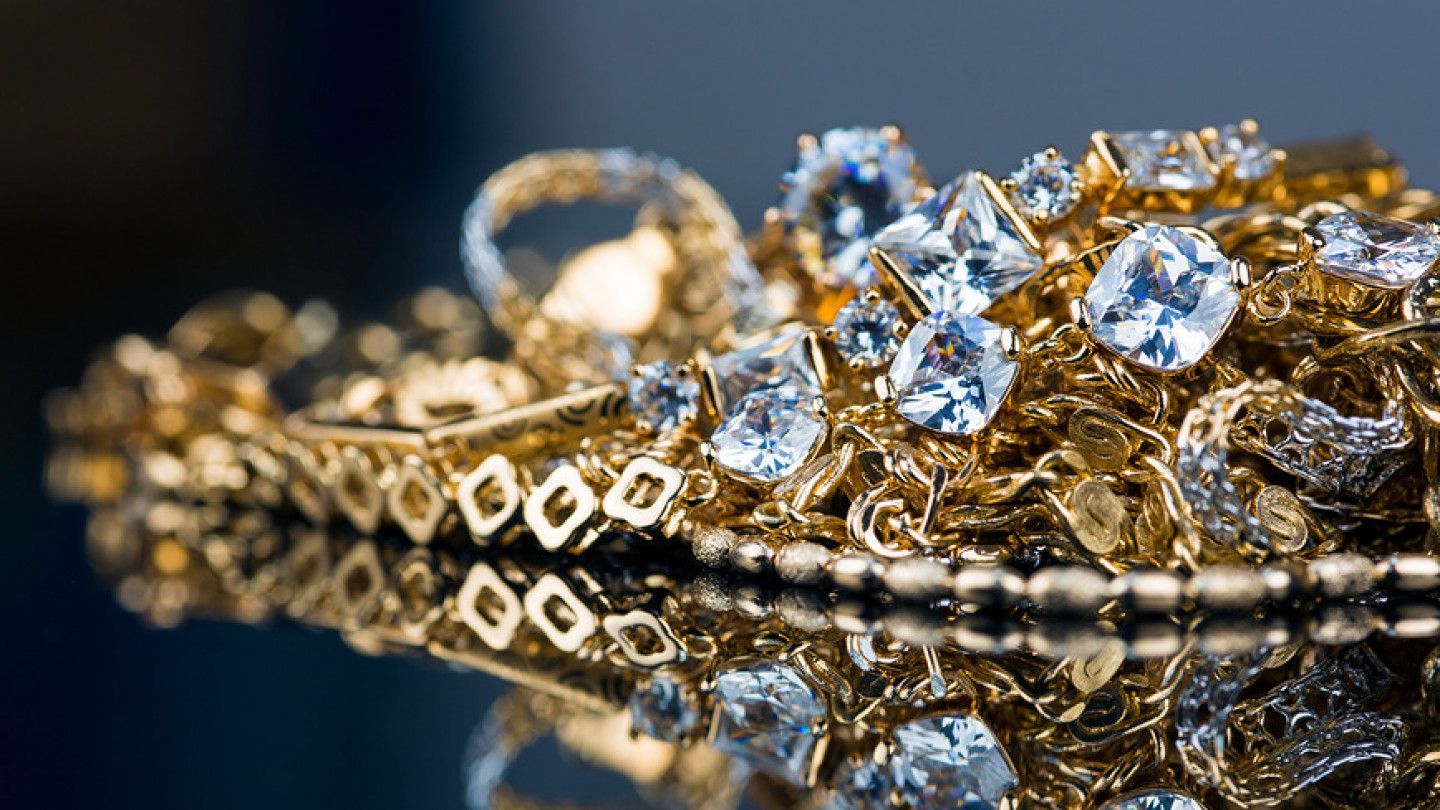 A pile of gold jewelry with diamonds on a table.