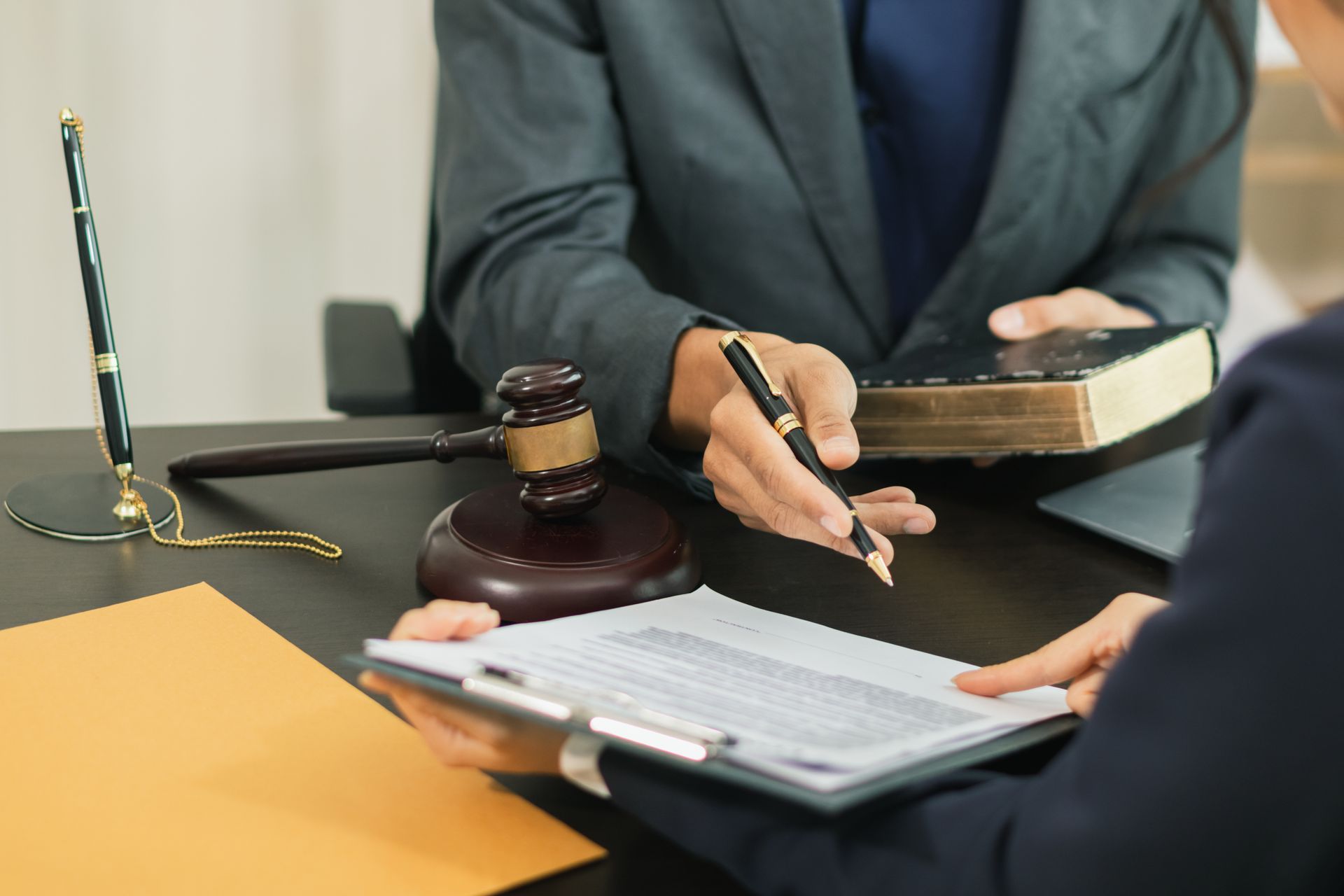 A lawyer and client discussing legal documents in a professional office setting