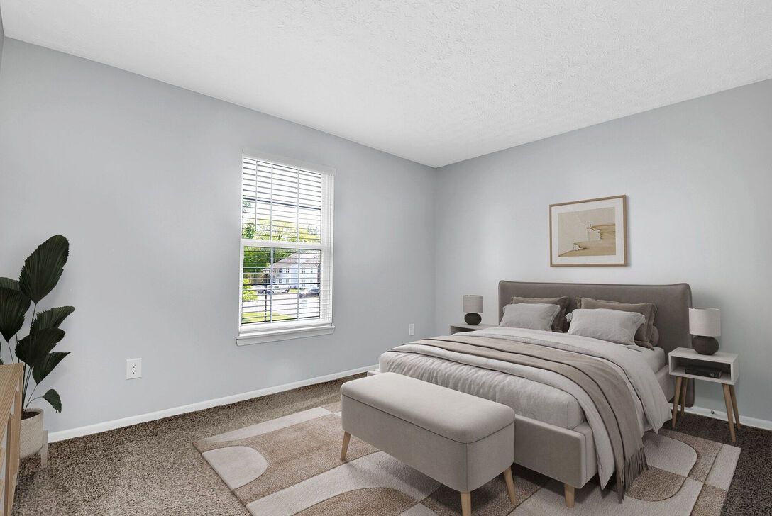 Minimal bedroom with gray walls, a bed, bench, nightstands, window, and a potted plant.