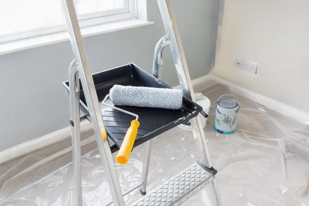 A man is working on a wall in a room.