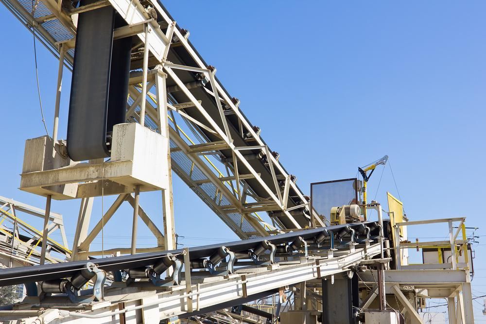 A Conveyor Belt in a Factory With a Blue Sky in the Background — Chooks Sand And Gravel In Cannonvale, QLD