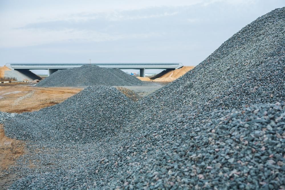 A Pile of Gravel on a Construction Site With a Bridge in the Background — Chooks Sand And Gravel In Cannonvale, QLD