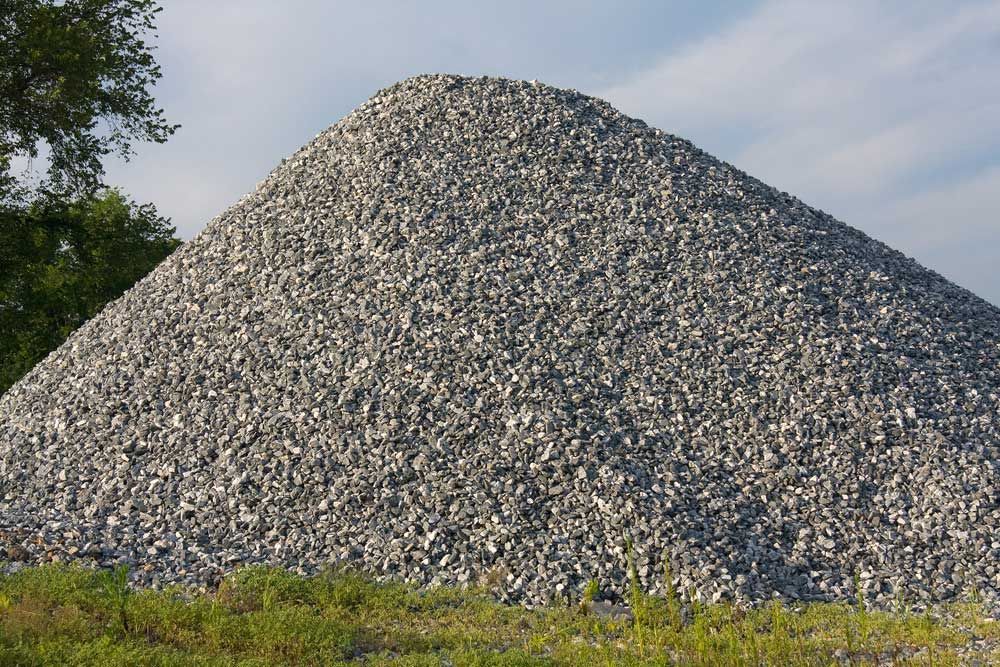 Pile of Gray Gravel on A Grassy Verge — Chooks Sand And Gravel In Bowen, QLD