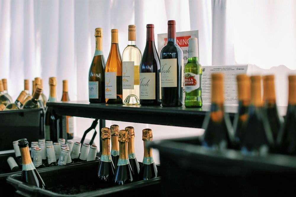 Assorted wine and champagne bottles displayed on shelves in a bright indoor setting.