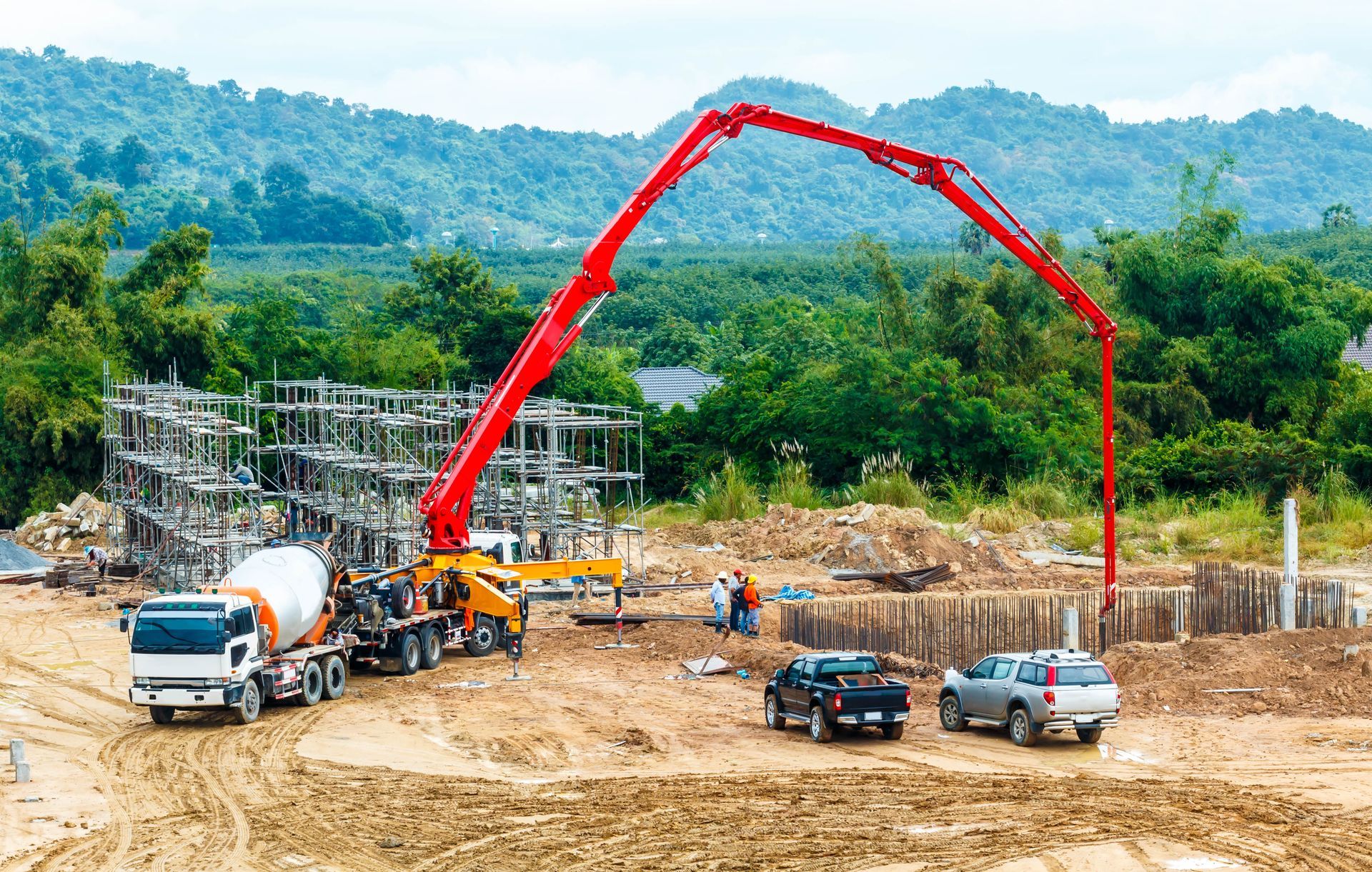 Concrete pumping services at a construction site with a boom pump truck pouring concrete.