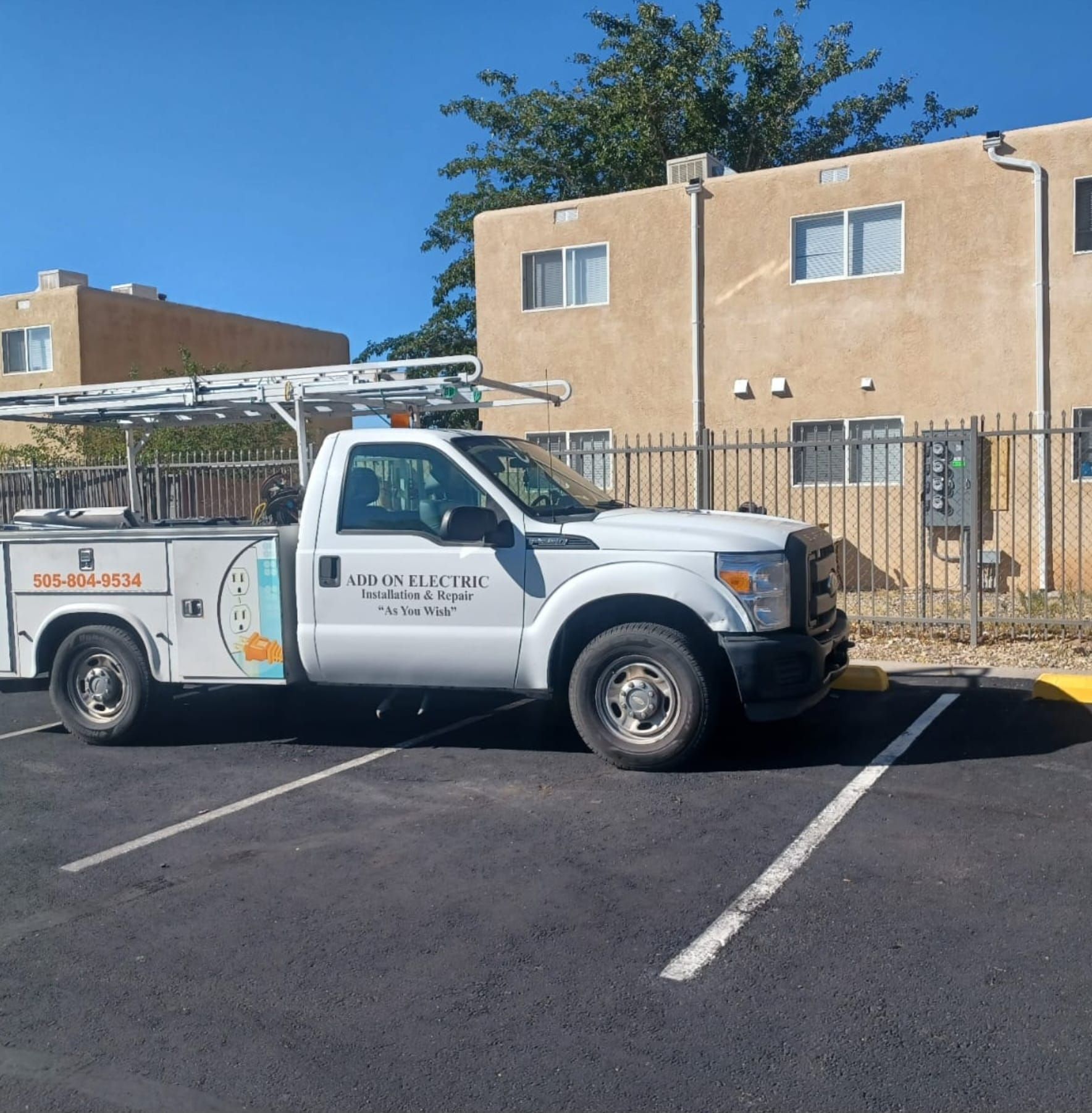 A white utility truck is parked in a parking lot