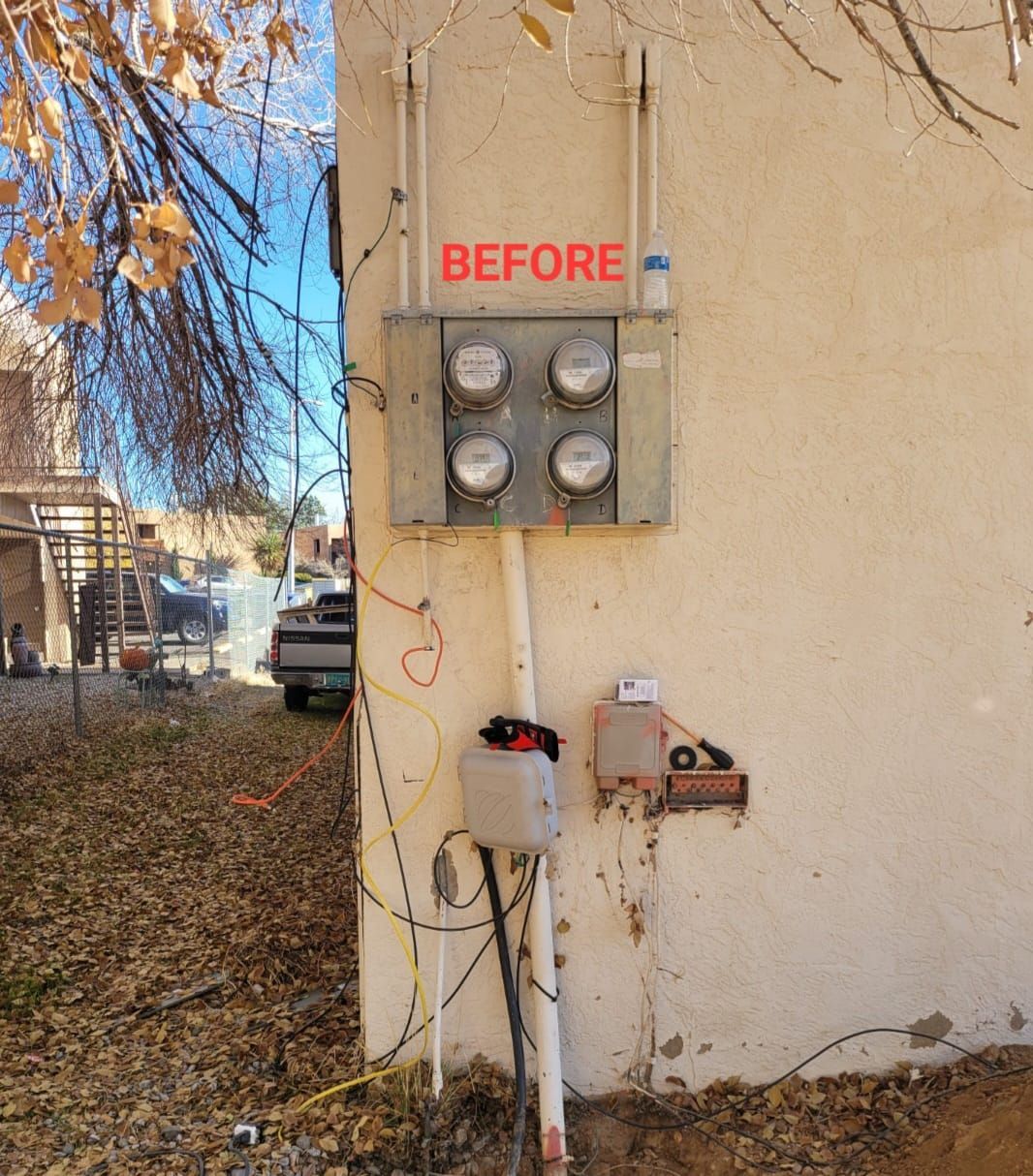 Before sign on an exterior wall beside electrical meters and utility boxes.