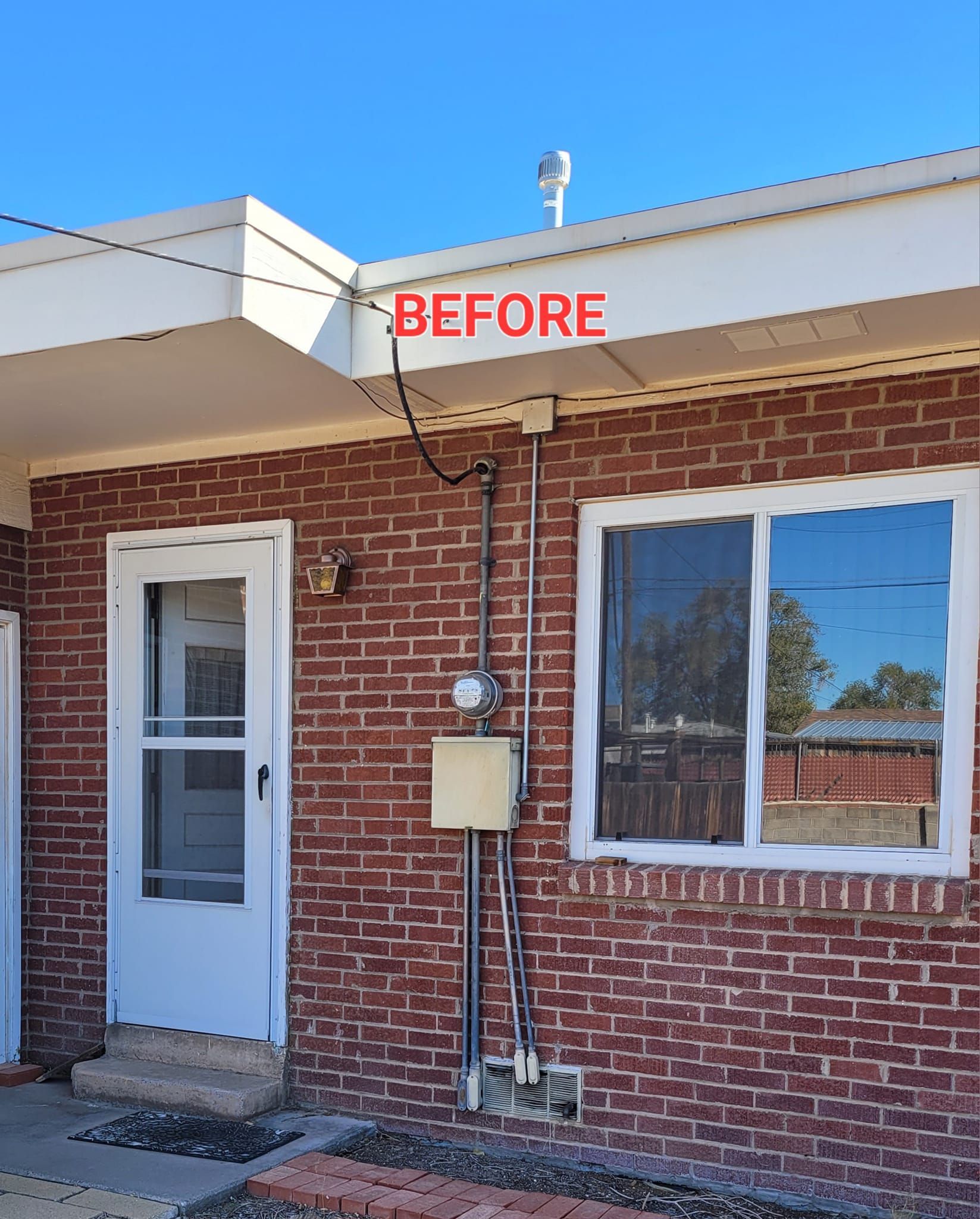 Brick building exterior with white door and window, labeled “BEFORE” above the roofline.