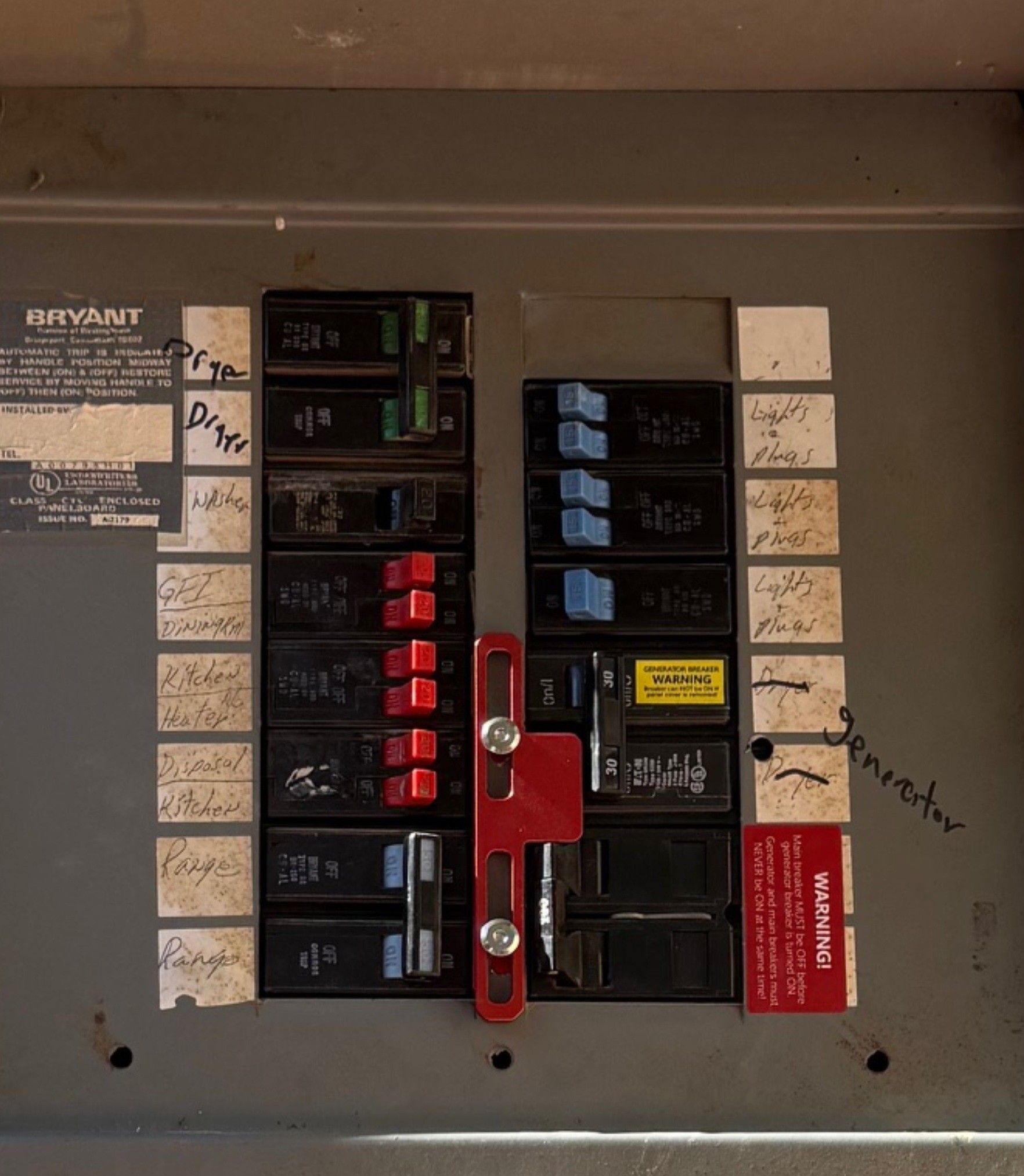 Electrical breaker panel with multiple black switches and red main disconnect lever inside a gray box