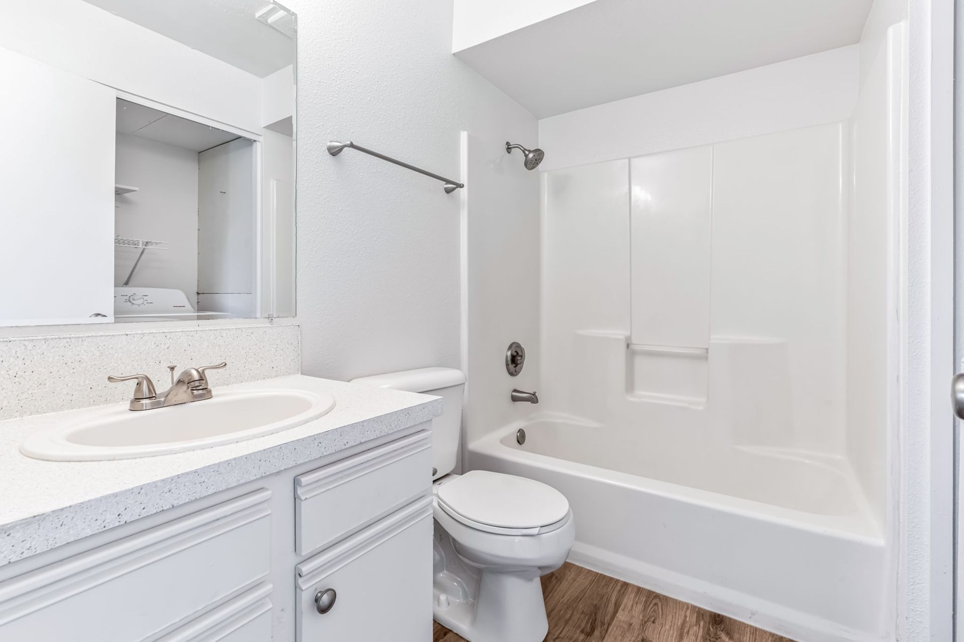 White bathroom with a sink, toilet, and bathtub.