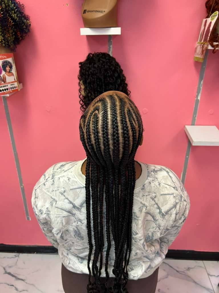 Two braided hairstyles displayed against a pink wall in a salon setting
