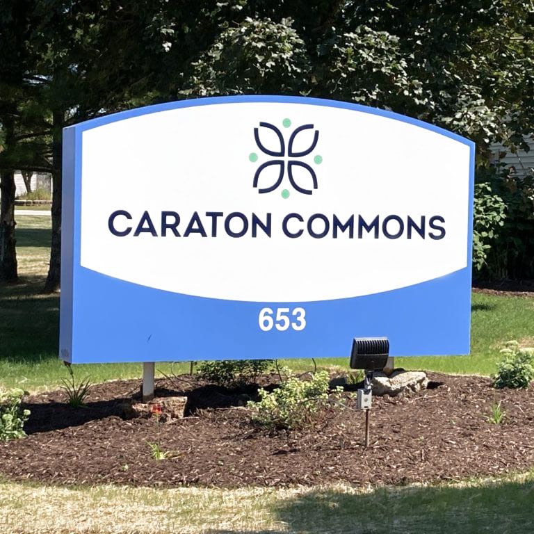 A blue and white sign for Caraton Commons