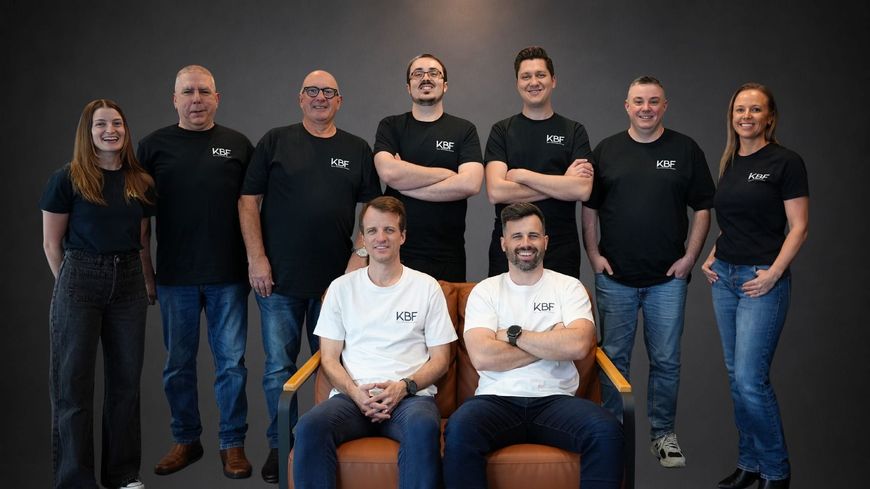 A group of men are standing in a row with their arms crossed.