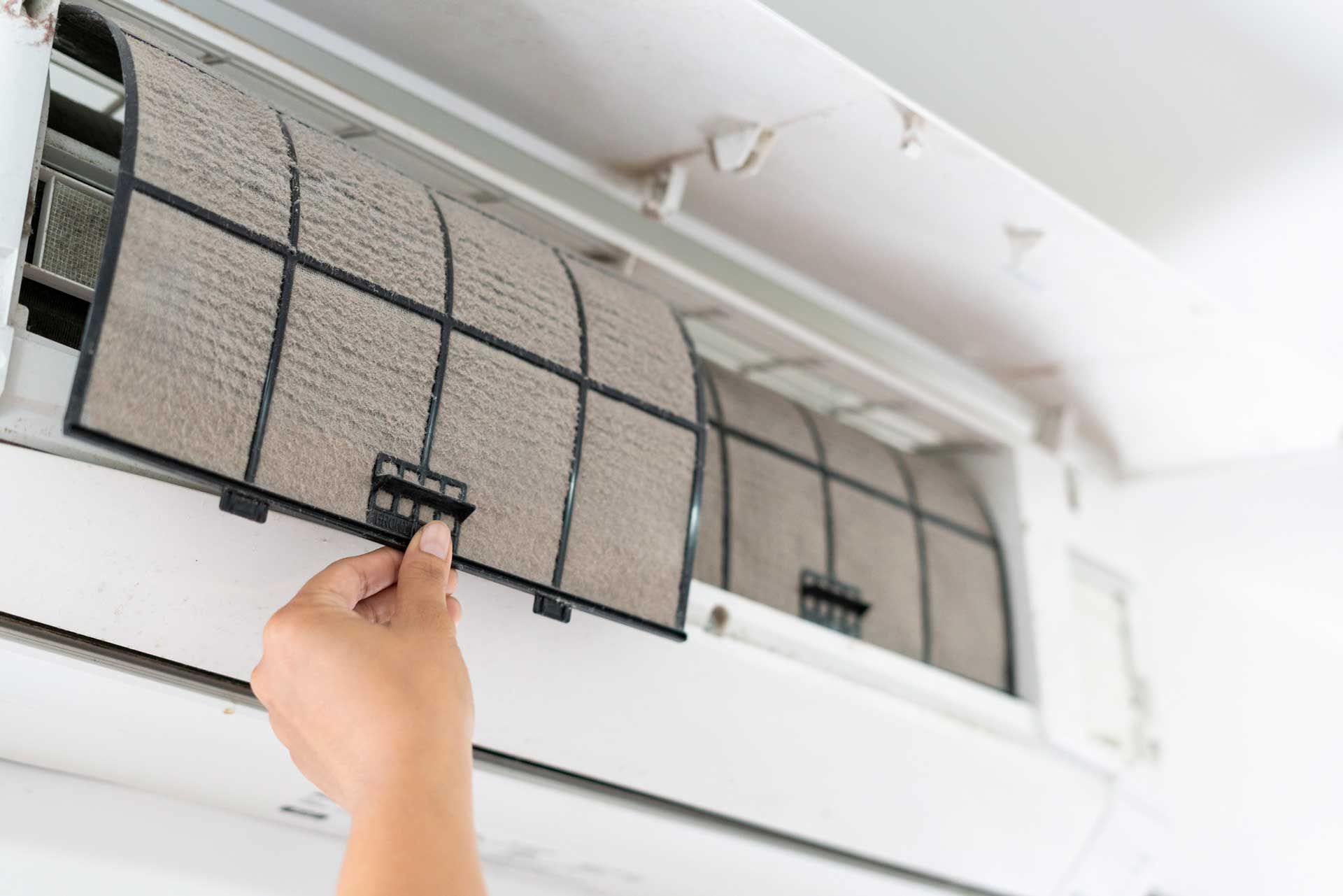 A person is cleaning the air conditioner filter.