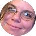 Person with glasses, smiling slightly, looking towards the viewer.