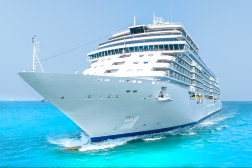 Large white cruise ship sailing on bright turquoise water under a clear blue sky