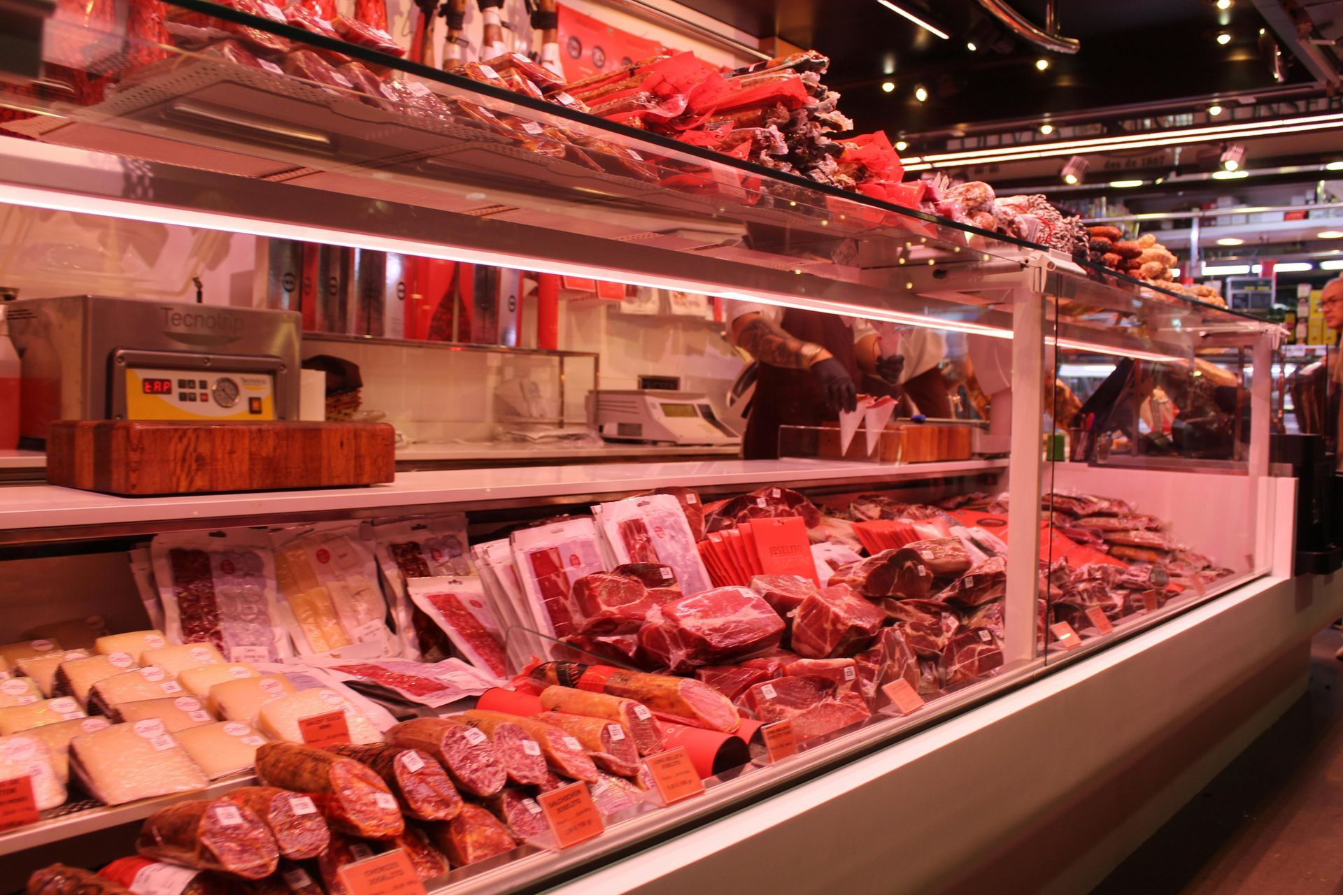 A butcher shop filled with lots of meat and cheese.