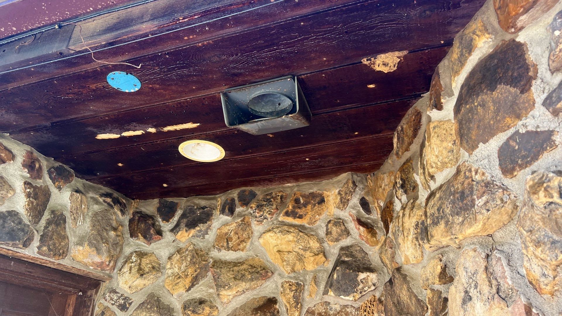 A room with a stone wall and a wooden ceiling.