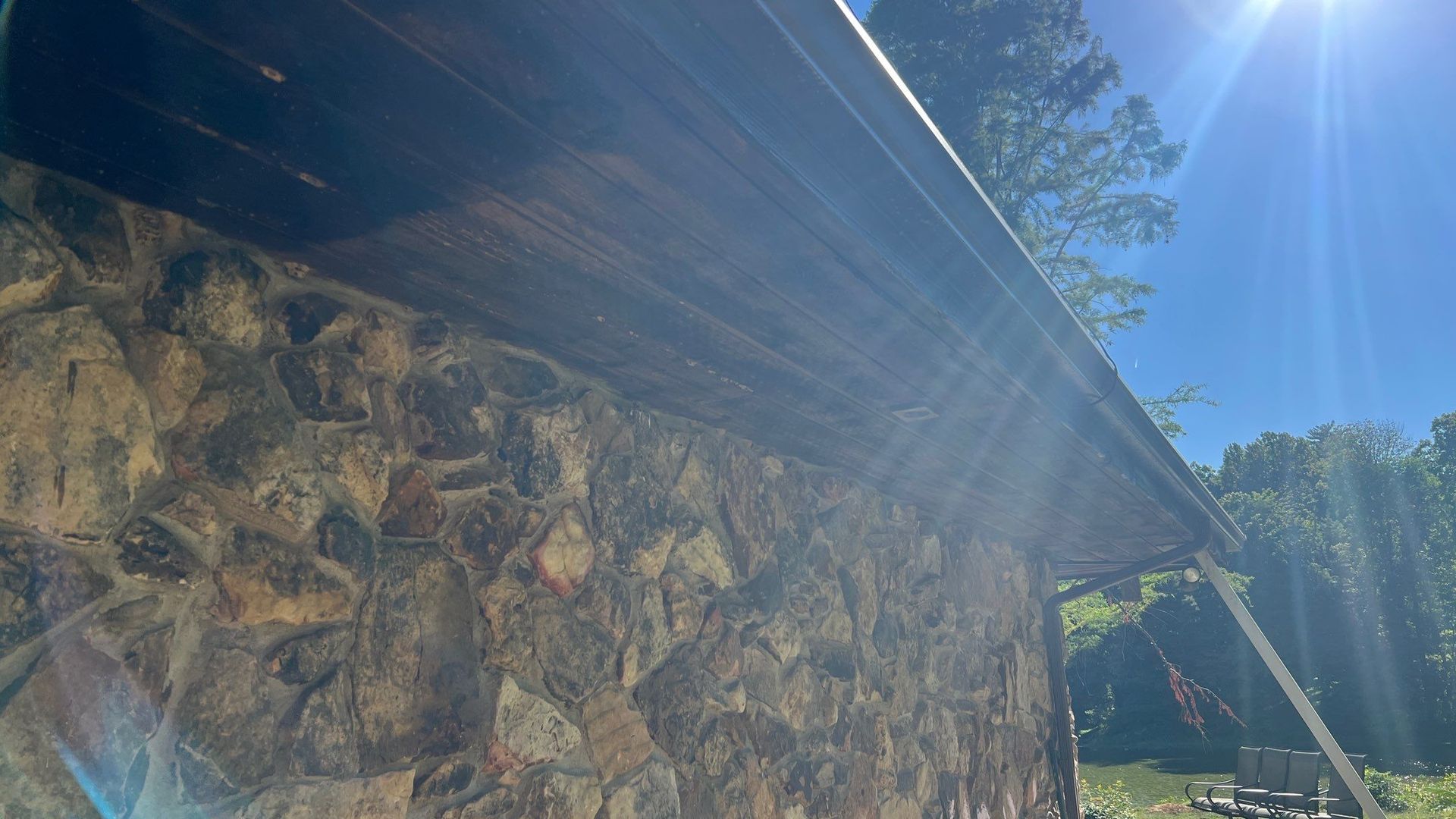 A stone wall with a gutter on the side of it.