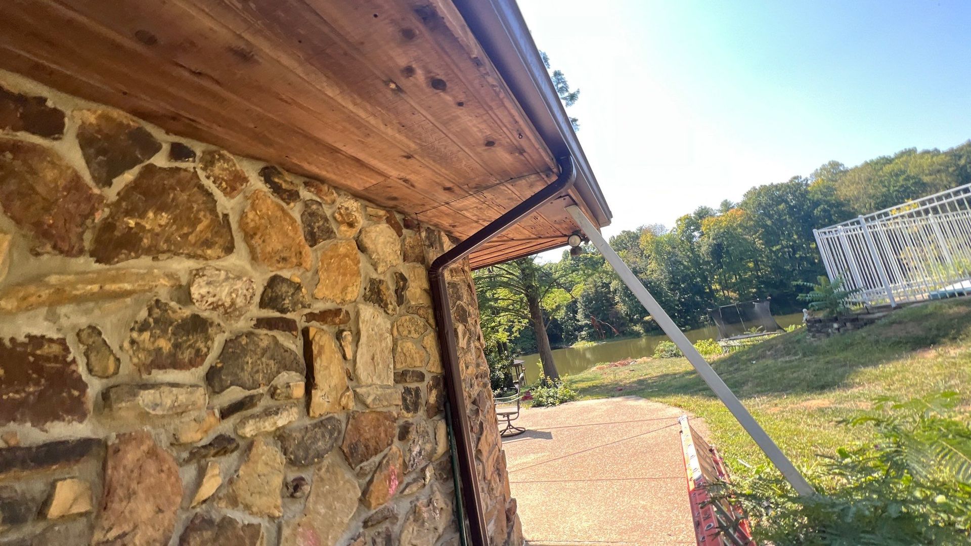 A stone wall with a gutter on the side of it.