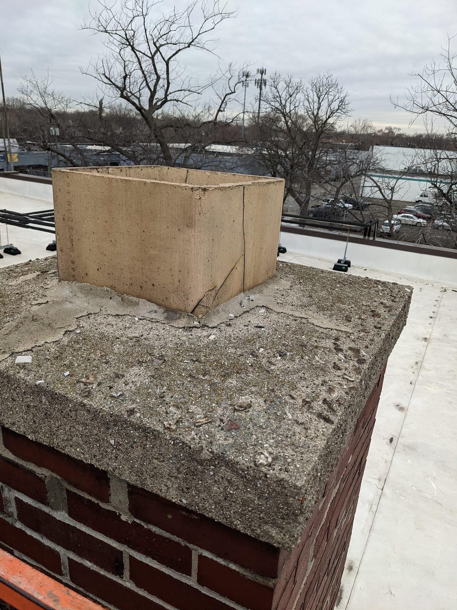 A brick chimney sitting on top of a white roof.