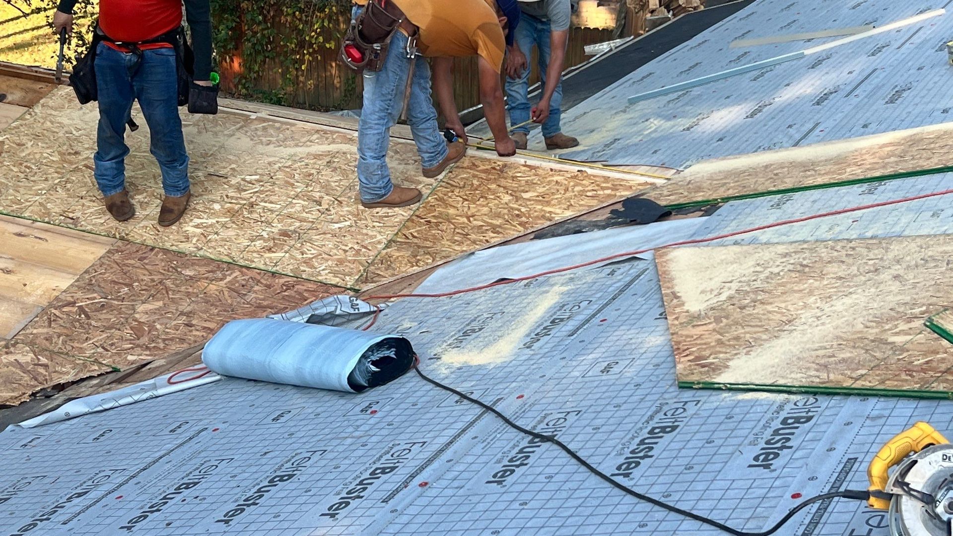 A group of men are working on a roof.