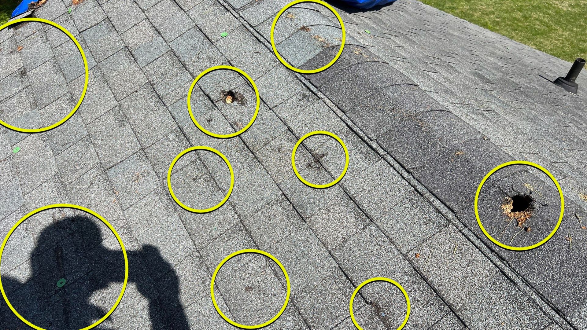 A person is taking a picture of a roof with hail damage.