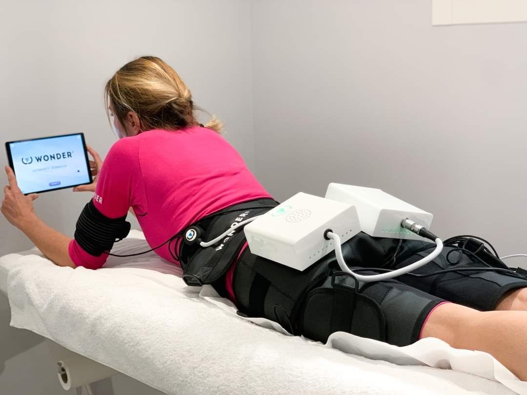 Une femme est allongée sur un lit en utilisant une tablette.