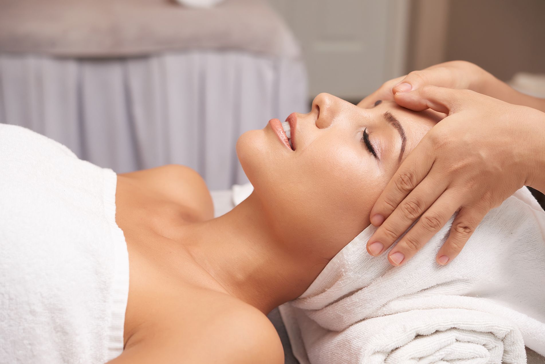 Une femme reçoit un massage du visage dans un spa.