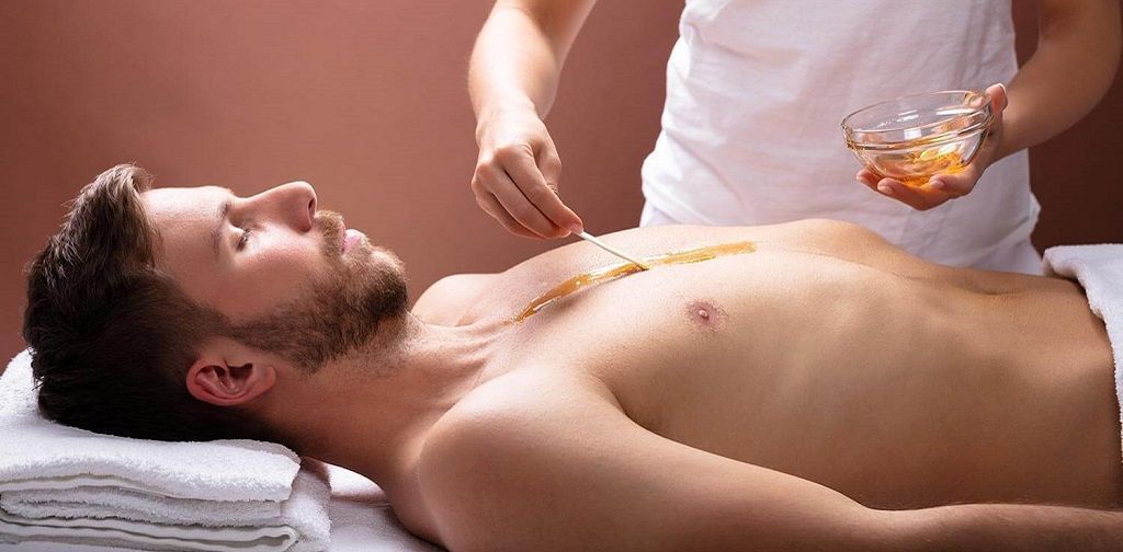 Un homme torse nu se fait masser dans un spa.