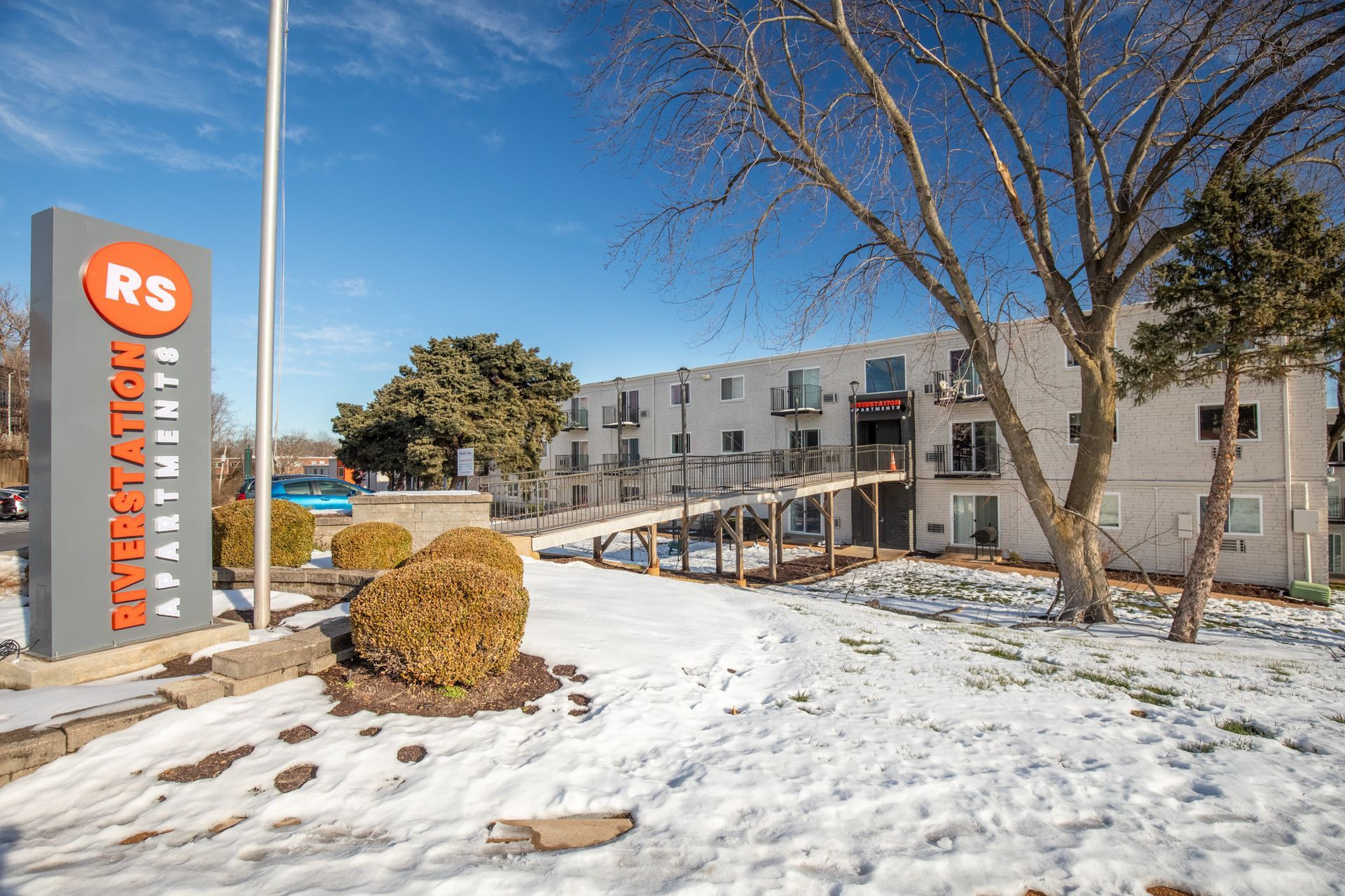 A building with a sign in front of it is covered in snow.