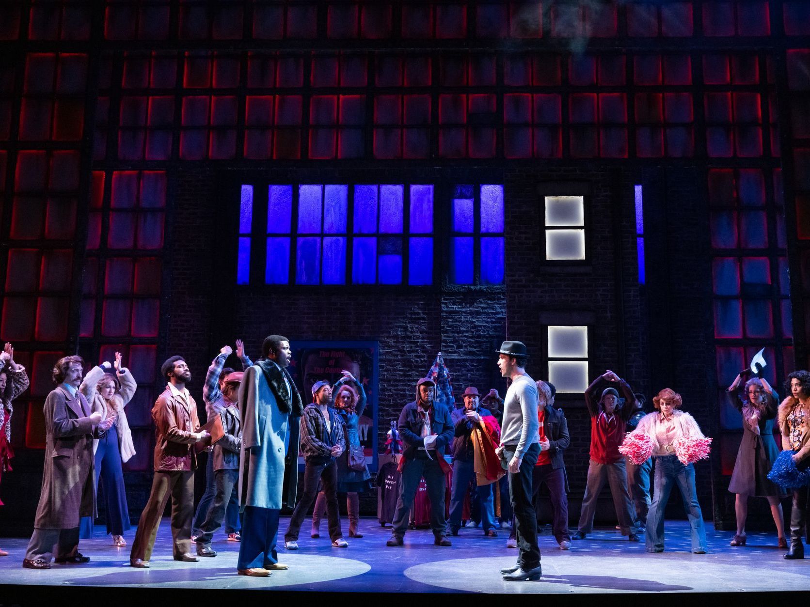 A group of people are standing on a stage in front of a building.