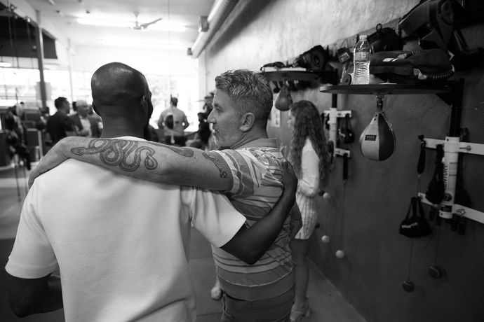 A small child practicing throwing punches with a man.