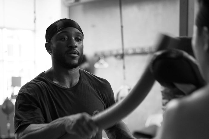 Two men are boxing in a boxing ring in a gym.
