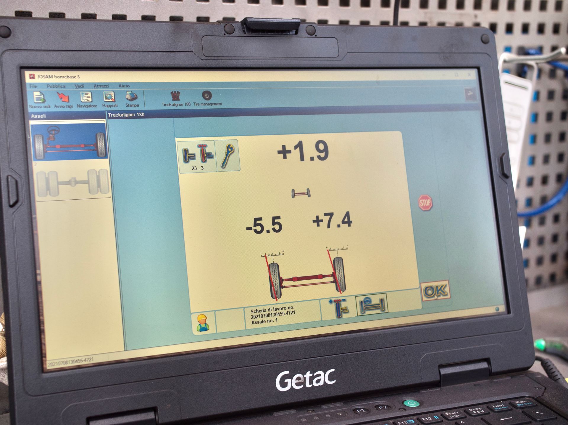 Schermo di un computer portatile che mostra un test di allineamento delle ruote di un veicolo. I numeri indicano le letture delle misurazioni.