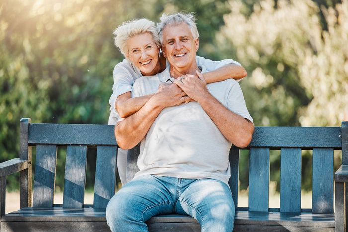 an senior couple is sitting at a table drinking tea, reading and enjoying life