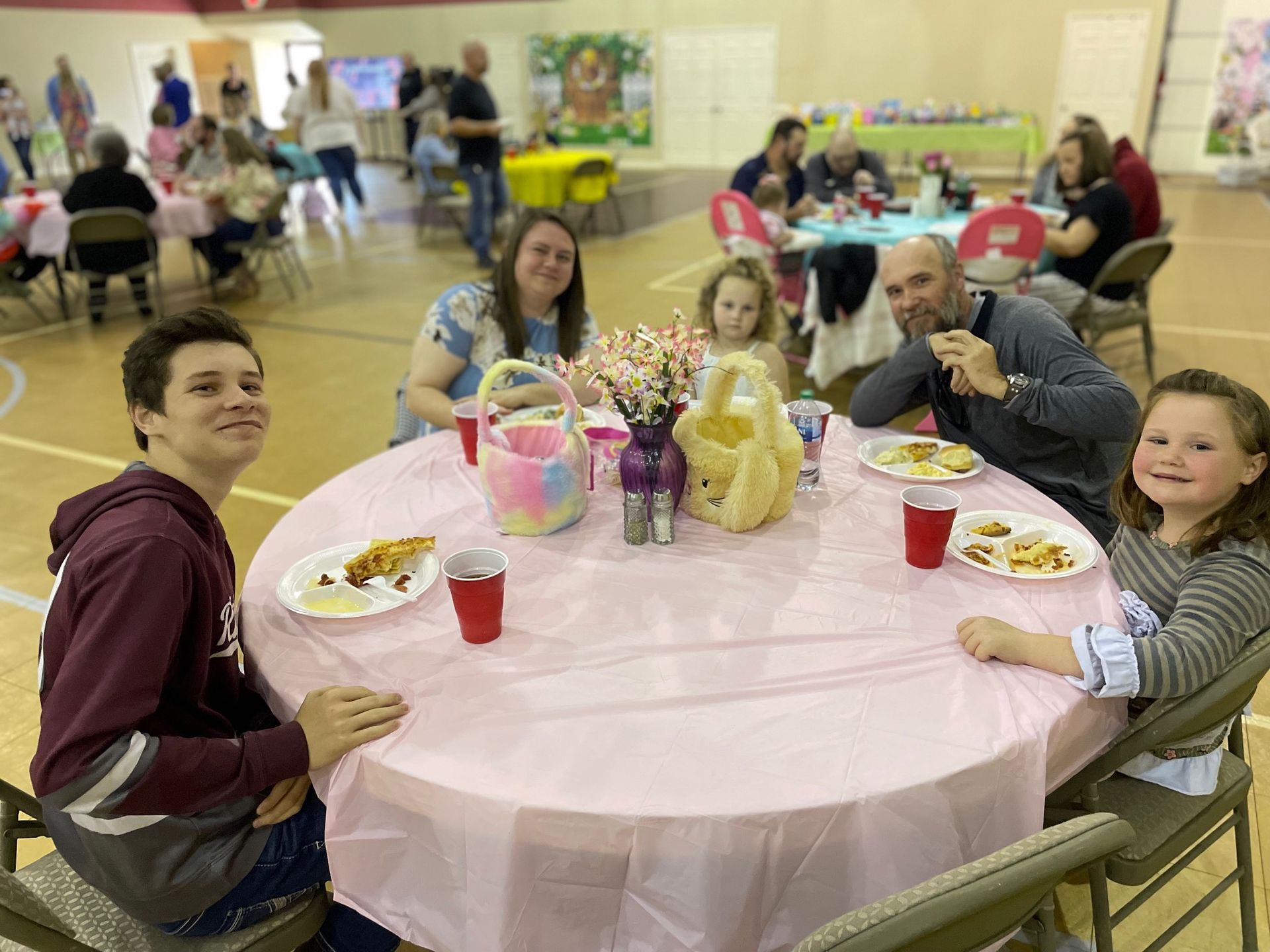 A group of people are sitting at a table with plates of food.