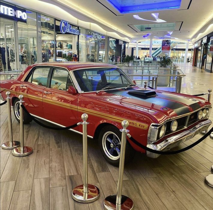 A red car is parked in a shopping mall